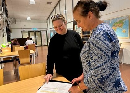 Bilde av to franske lærere som ser på skolearbeid i Norge - Klikk for stort bilete